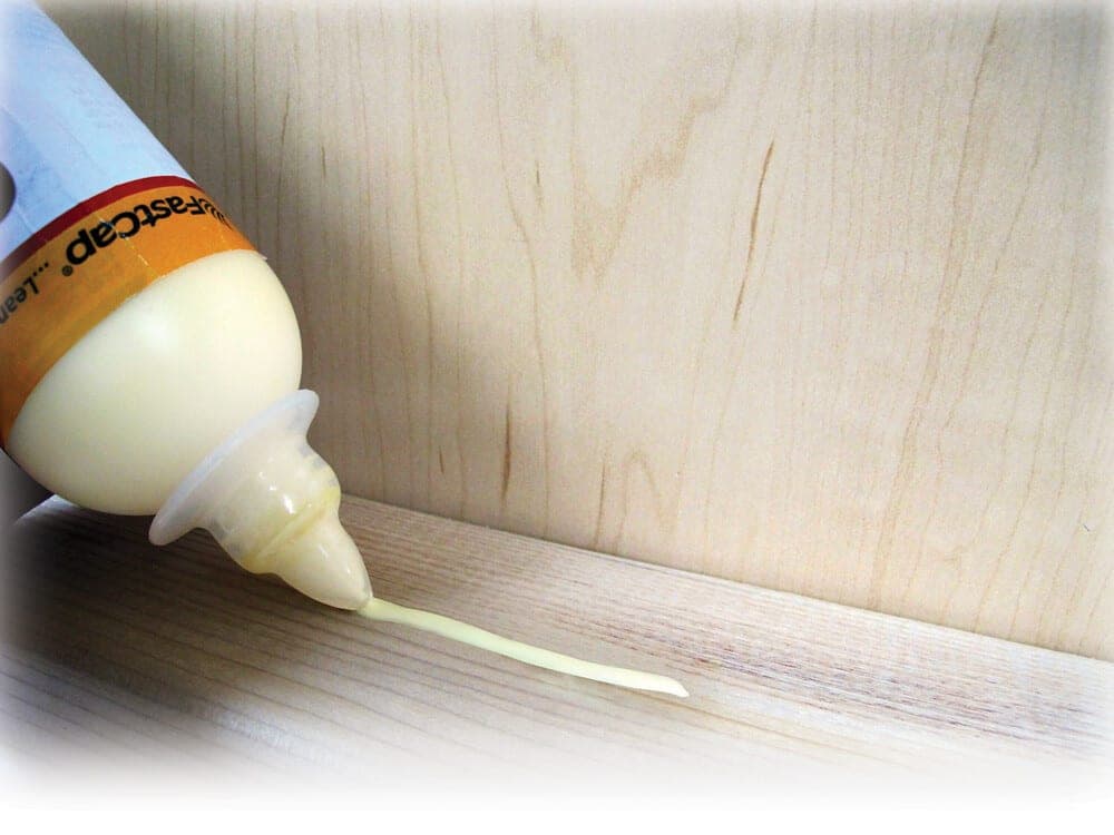 A bottle of thin plastic cement with a brush applicator